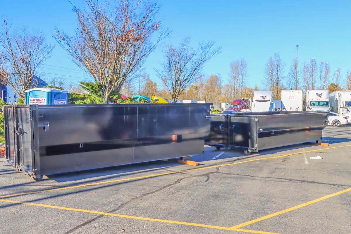 Professional dumpster rental service with roll-off container on residential driveway in Fort Lewis